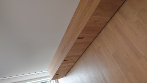 Lång tv-möbel i modern minimalistisk stil med släta luckor med frästa fingergrepp i massiv vitoljad ek.